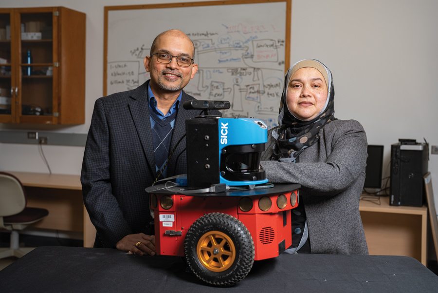 2 inventors with their social assistive robot they invtented