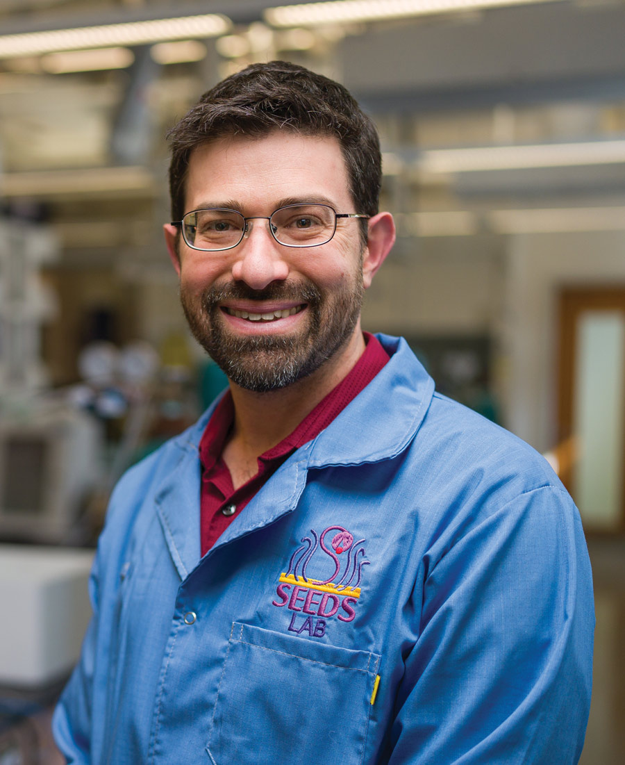 Jeffrey Halpern smiling while wearing a blue lab coat
